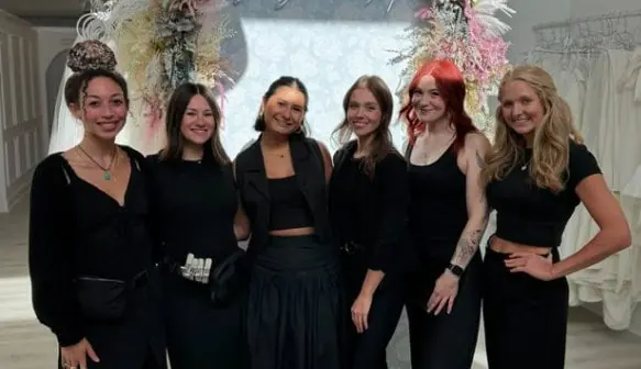 six female bridal stylists standing and smiling