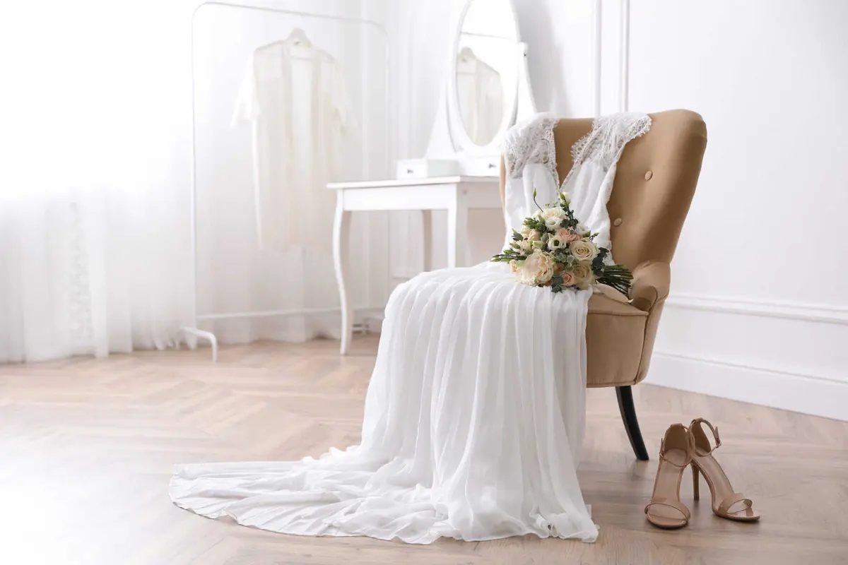 preowned wedding dress laying across a chair