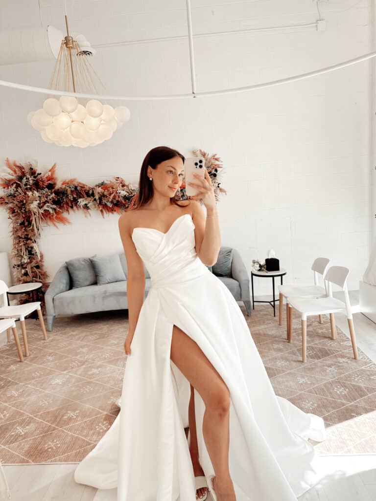 A woman wears a white, strapless ball gown.