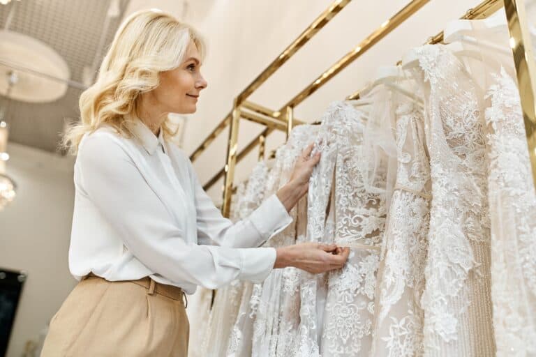 middle-aged woman browsing a rack of wedding dresses