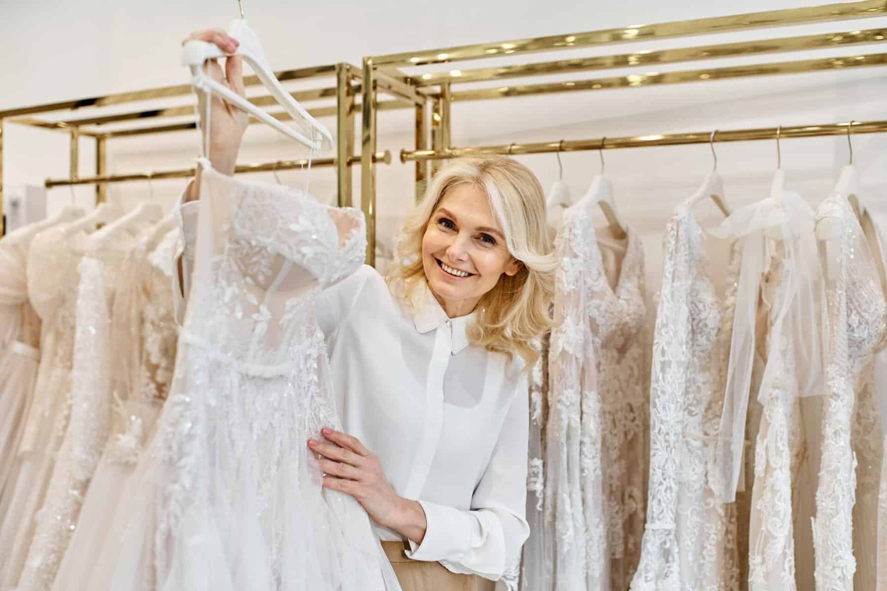 middle-aged woman holding a wedding gown