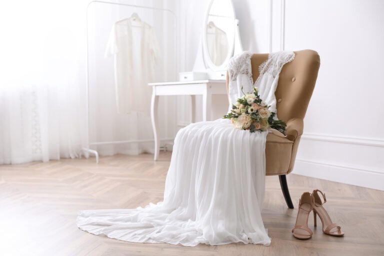 preowned wedding dress laying across a chair
