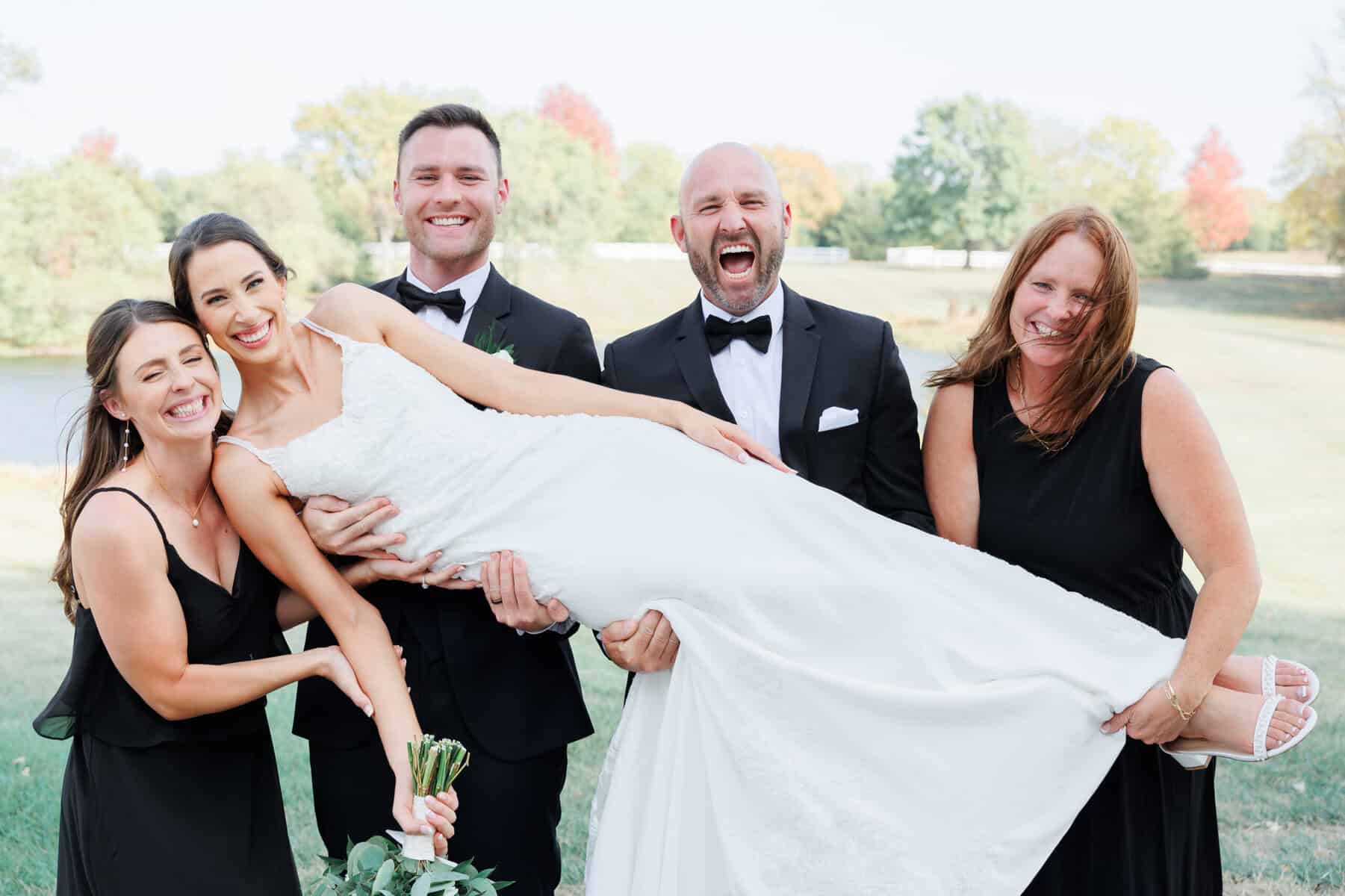 an image of a happy bride lifted by her husband and family.