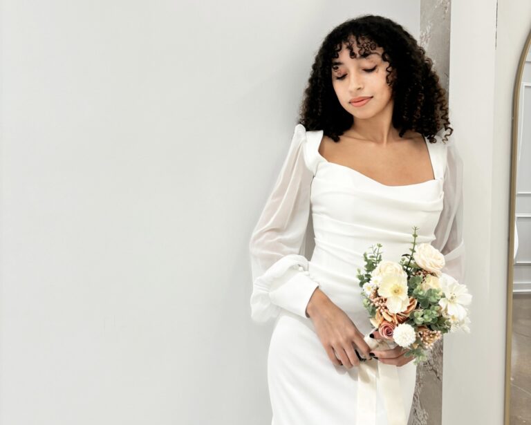 woman wearing a simple wedding dress holding a bouquet