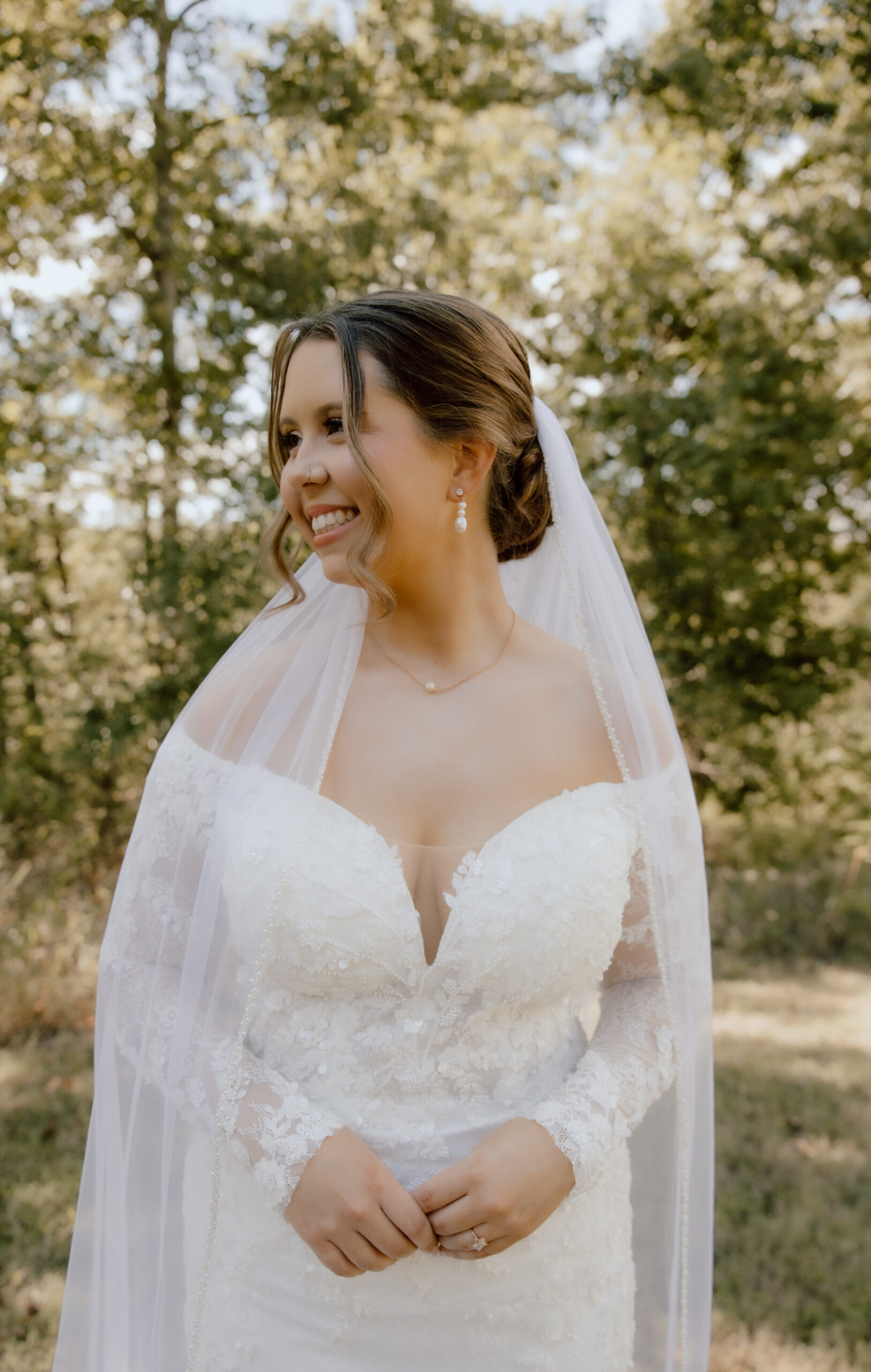 The bride wearing a stunning off-the-shoulder lace gown paired with cathedral veil.