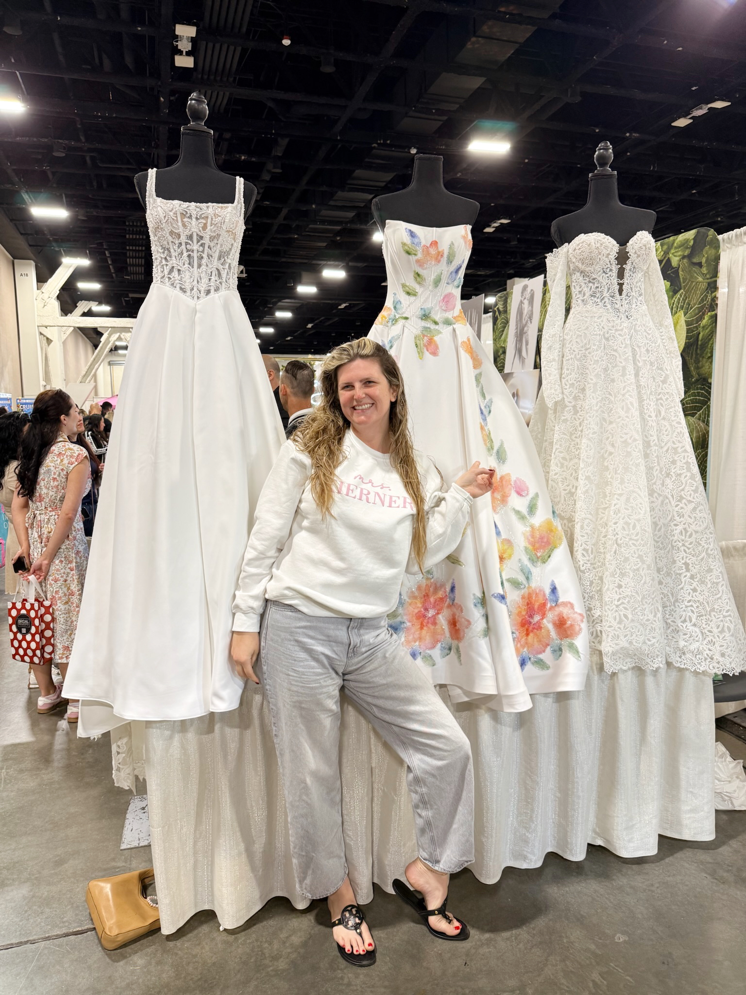excited woman take a post with Savvy bridal gowns during the wedding expo
