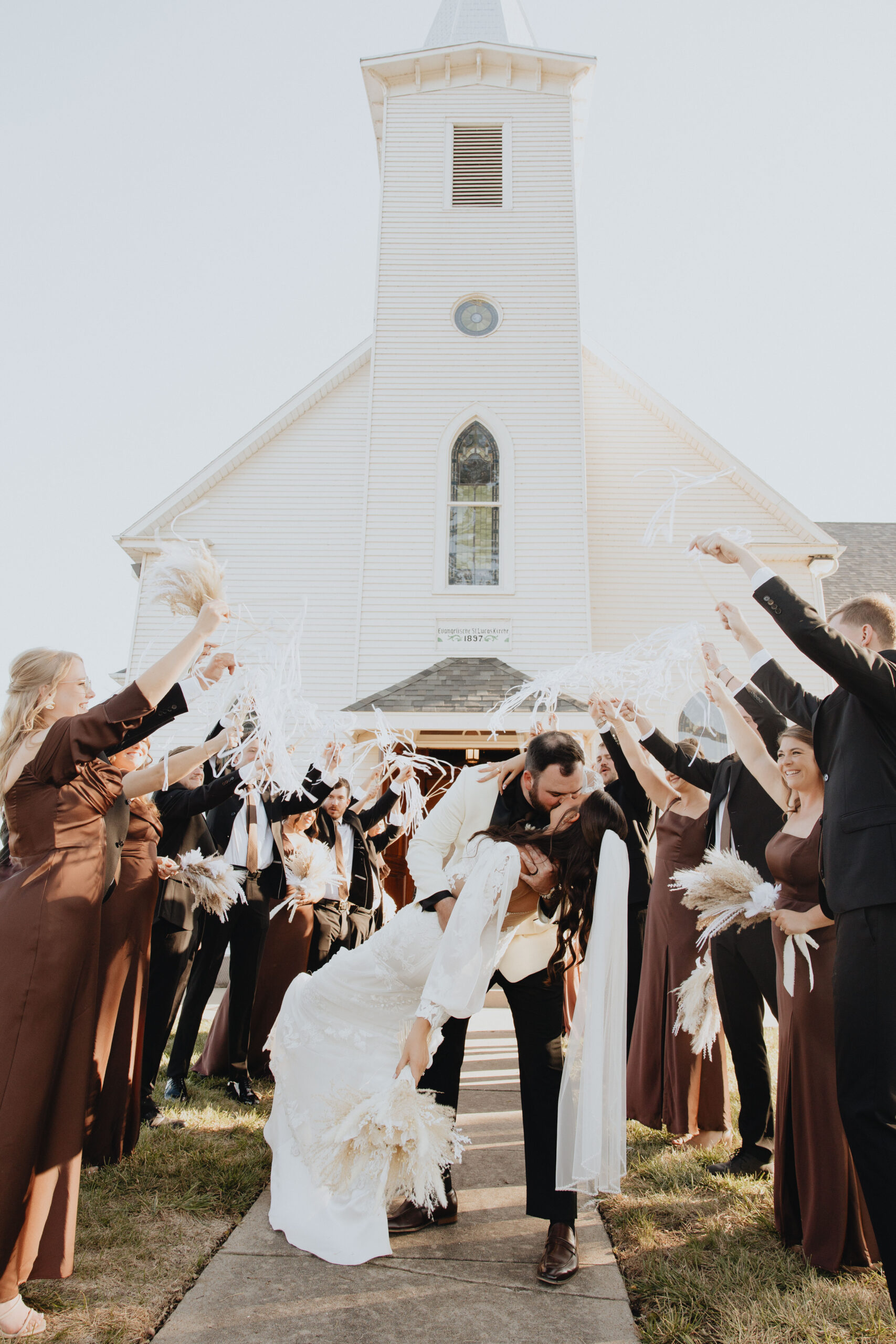Colby swept Kelsey into a romantic dip-kiss, the white church spire reaching toward the clear blue sky behind them.
