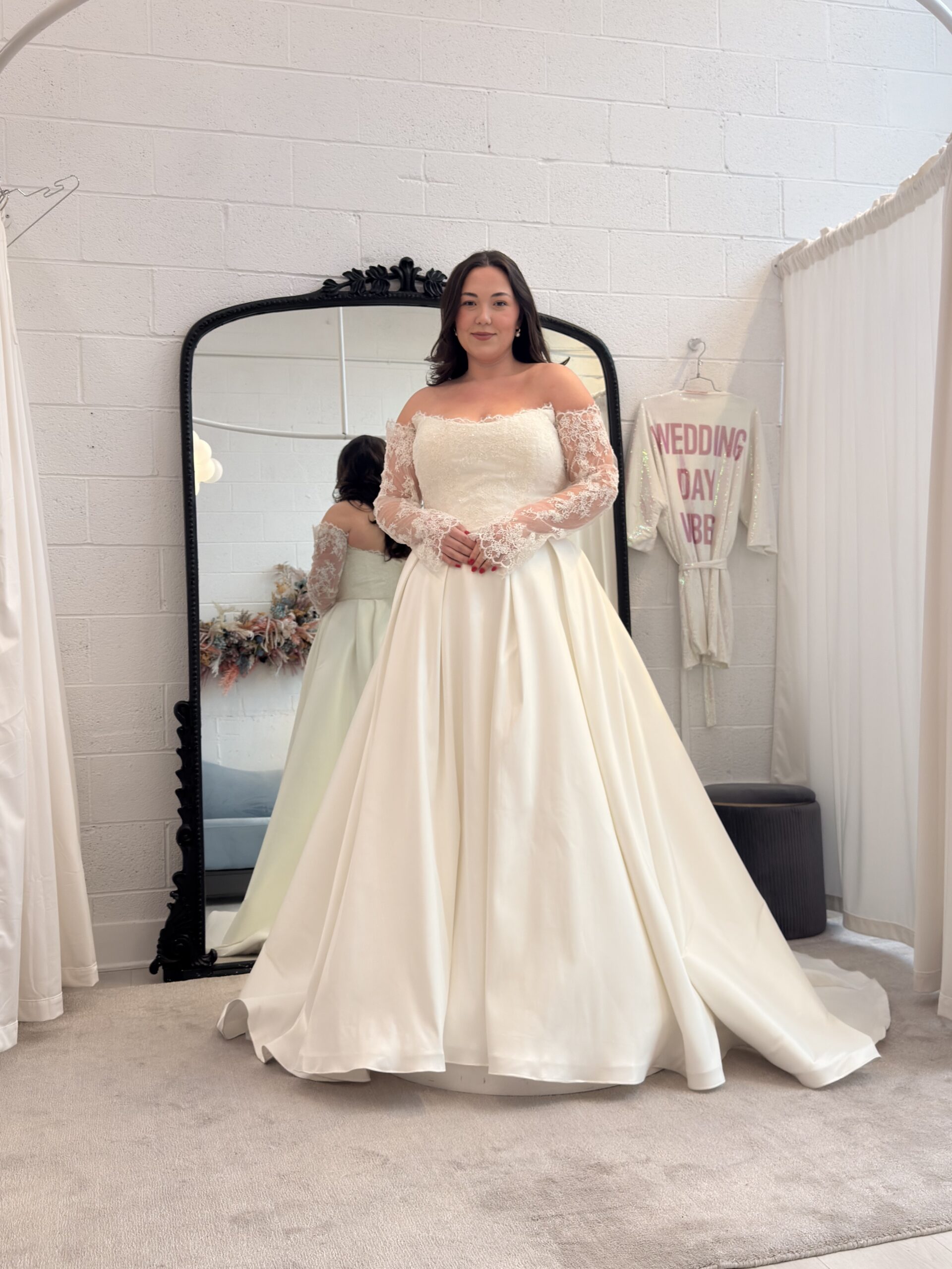 Josie wearing a beautiful white off-the-shoulder bridal gown with lace long sleeve.