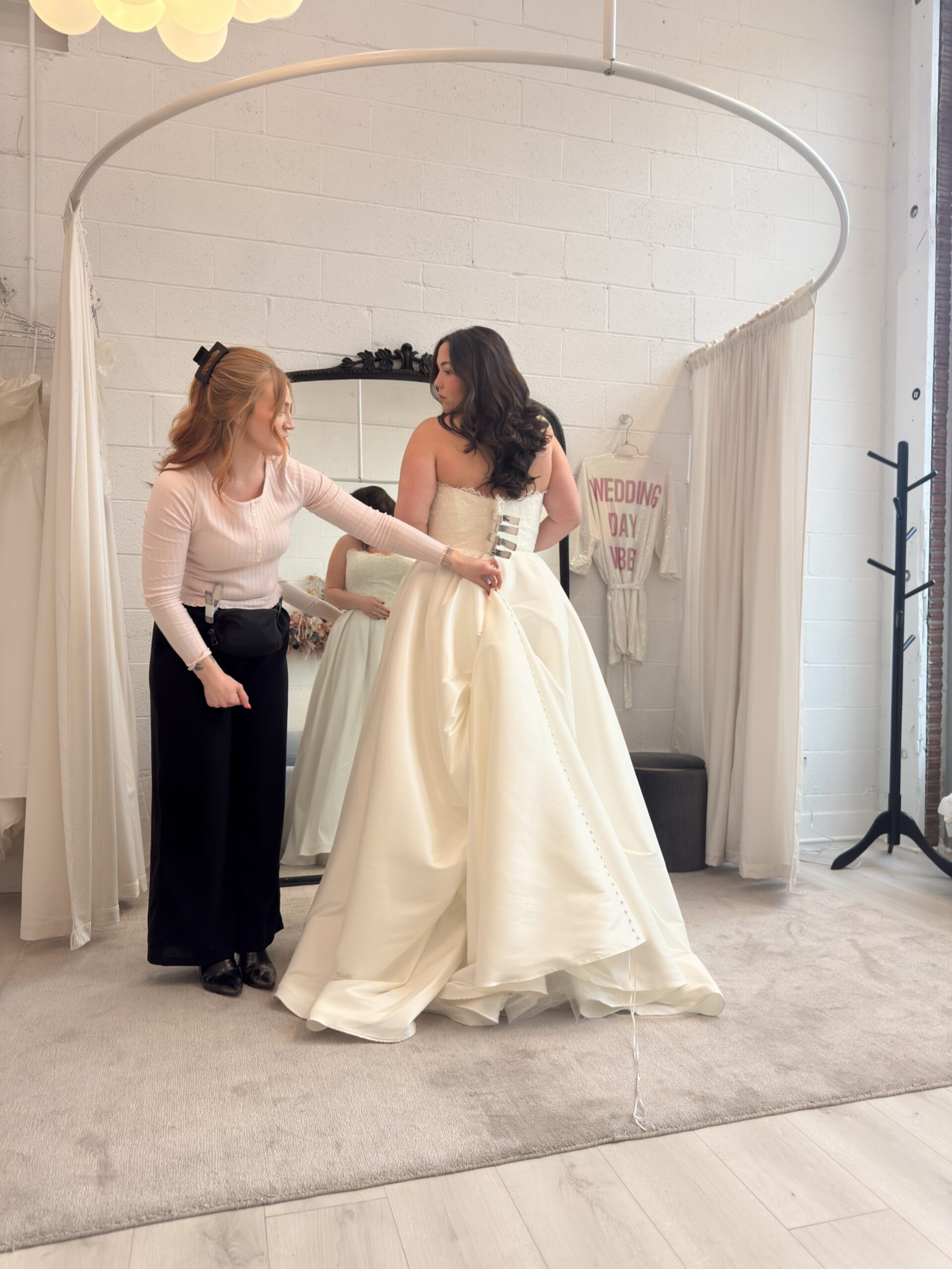 Bridal stylist Abby assisting Josie during her appointment.
