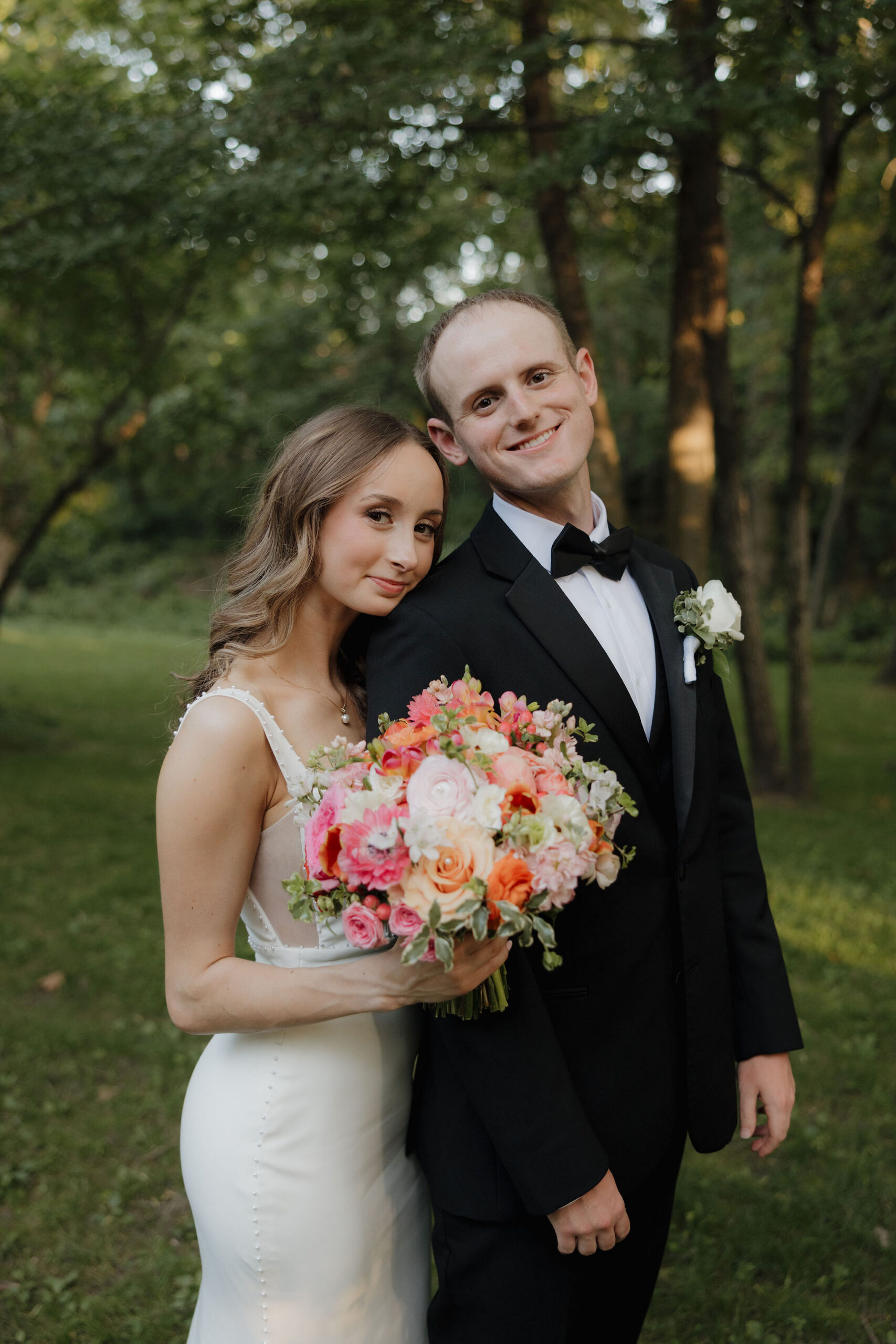 portrait image of Grace and Brett with beautiful greenery background of shaded tress