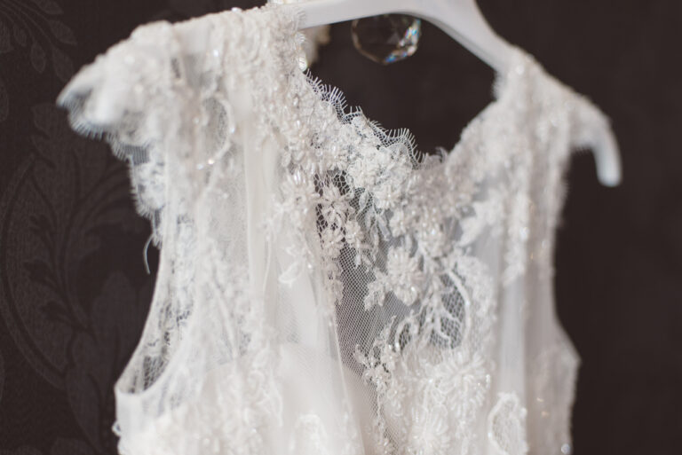 Close up of a lace wedding dress bodice on a hnager.