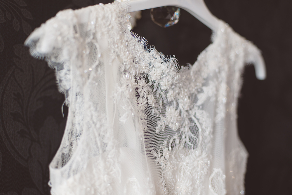Close up of a lace wedding dress bodice on a hnager.