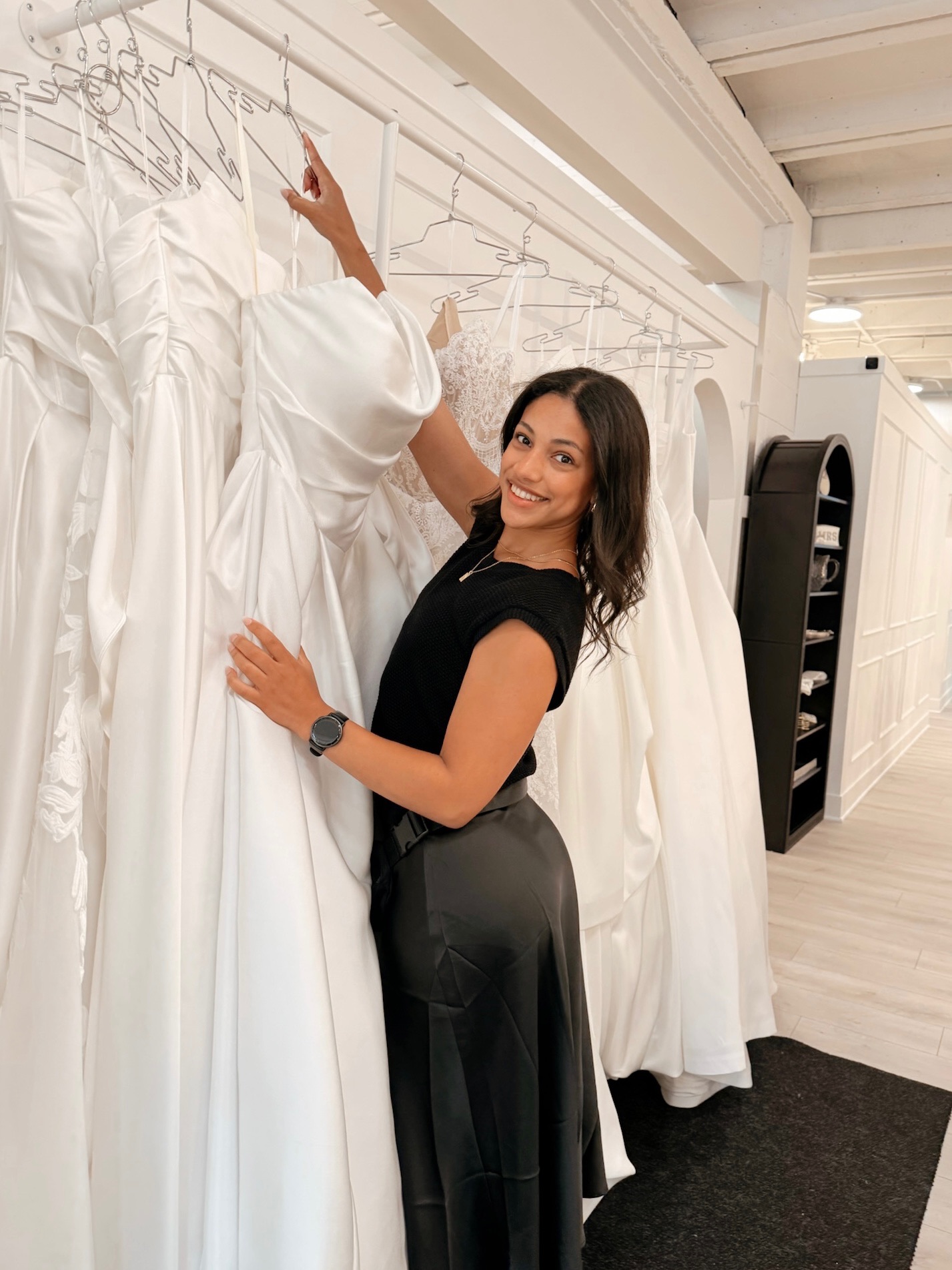 Bridal stylist pulling a wedding dress from the rack