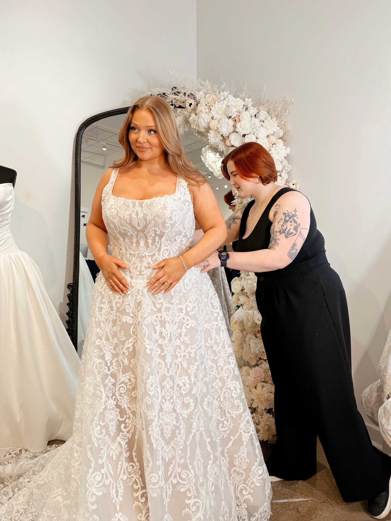 Bridal stylist help plus size bride try on wedding dress, wedding dress size