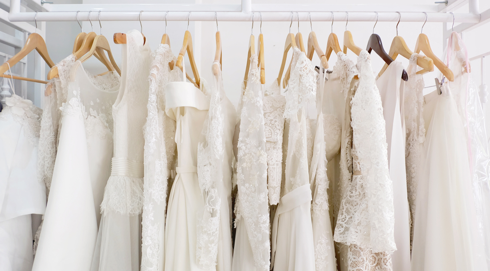 Various wedding dresses in different styles hanging on a clothing rack.
