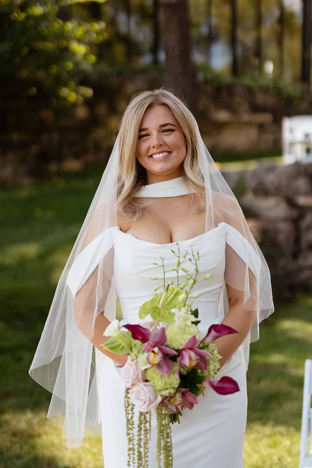 Sydney completed her bridal look with a long veil, creating an especially striking effect against the greenery surrounding the venue.