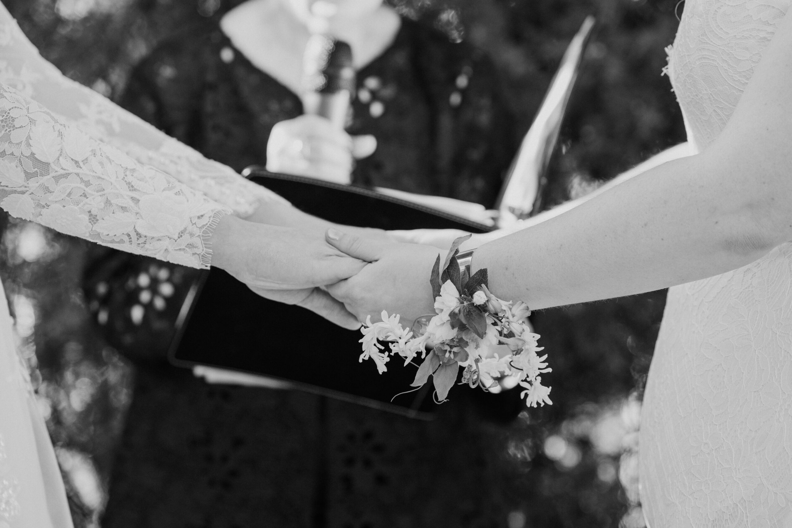 Caitlyn and Anna holding hands during their intimate outdoor wedding ceremony