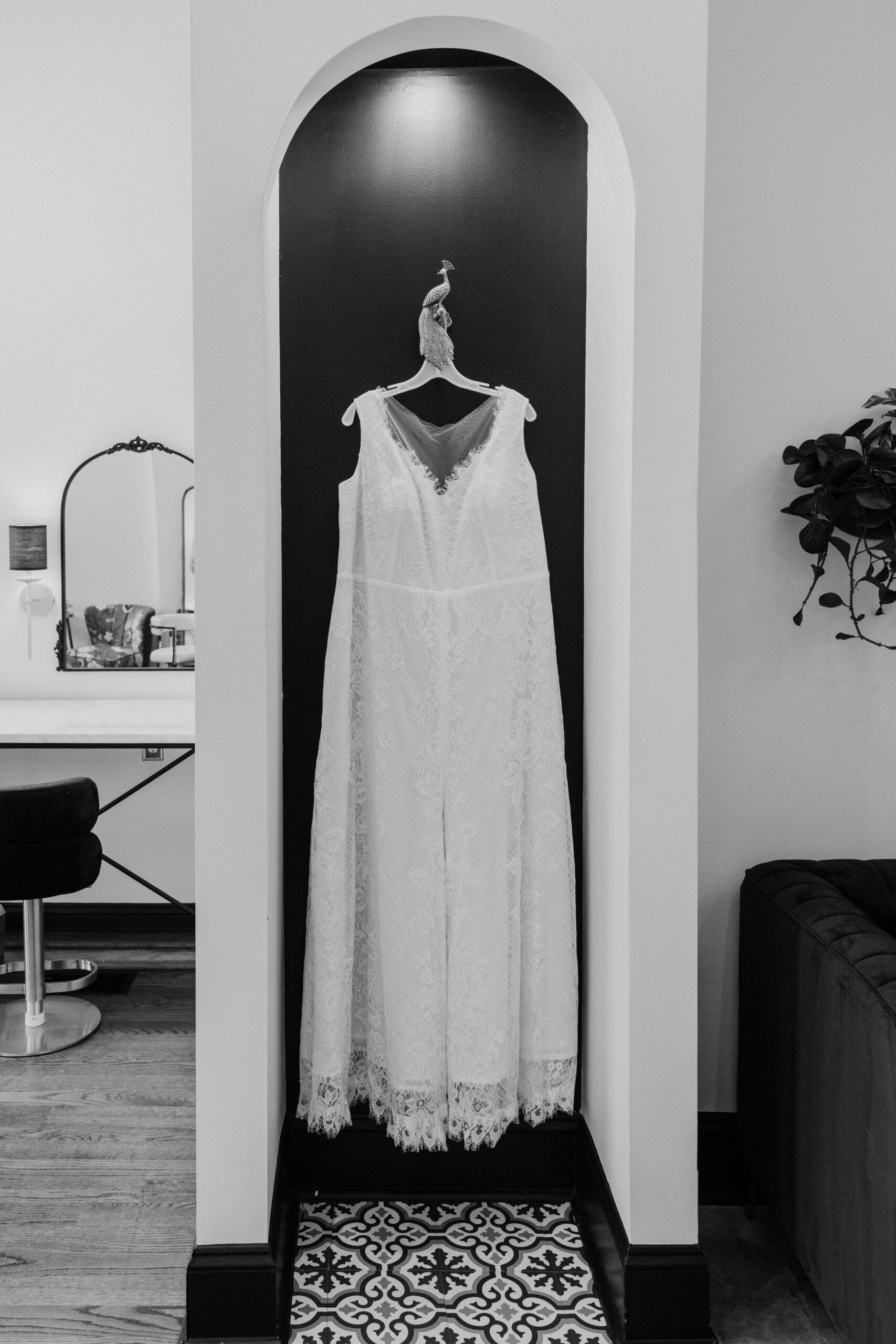 Anna’s sleeveless lace wedding dress hanging in an elegant bridal suite before the wedding.