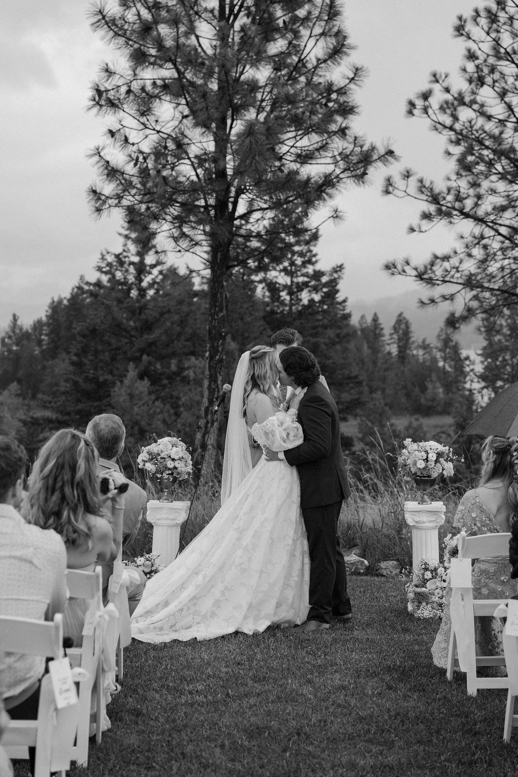 Bride and groom kissing during their outdoor wedding ceremony.