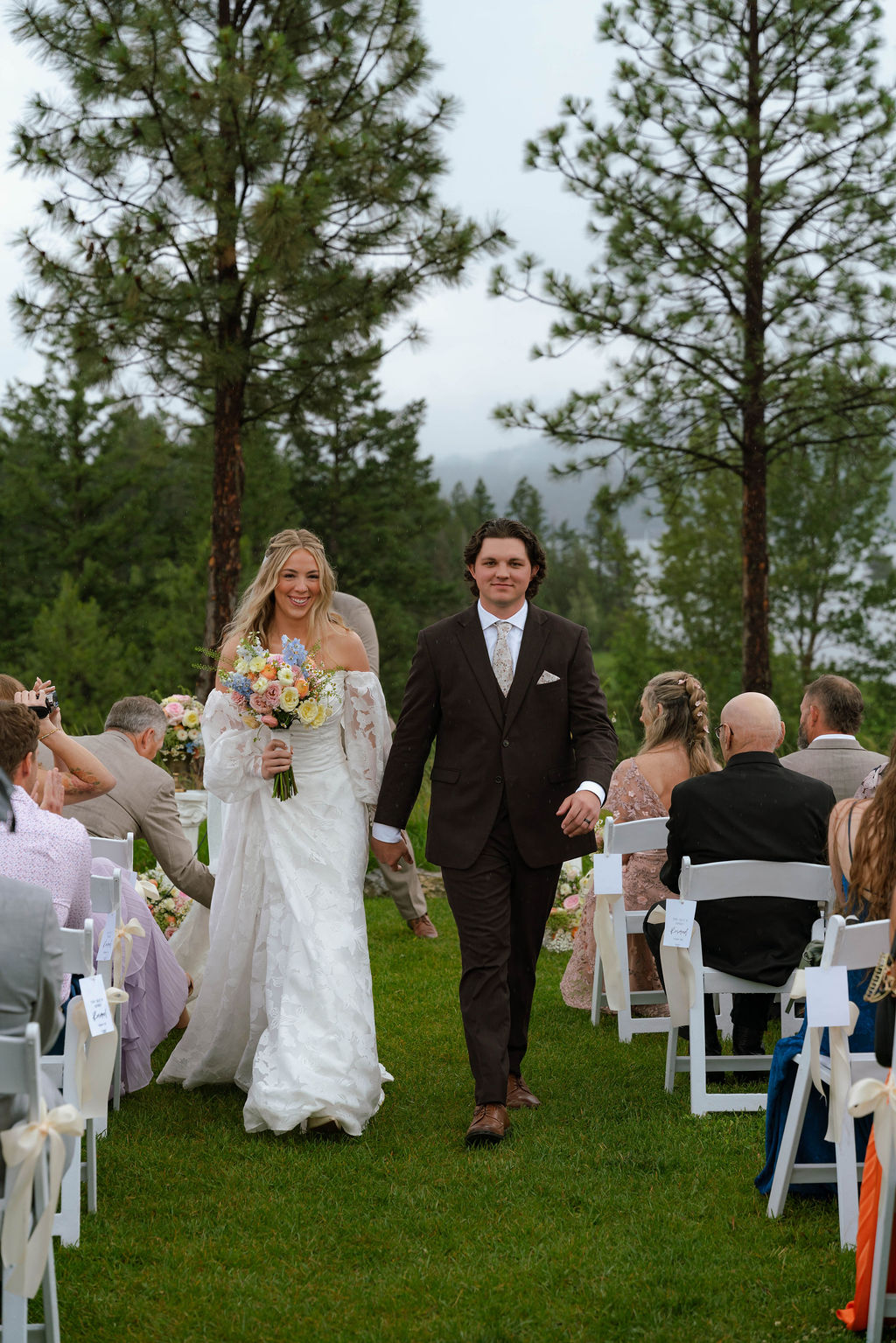 Newlywed bride and groom walking down the aisle after their ceremony.