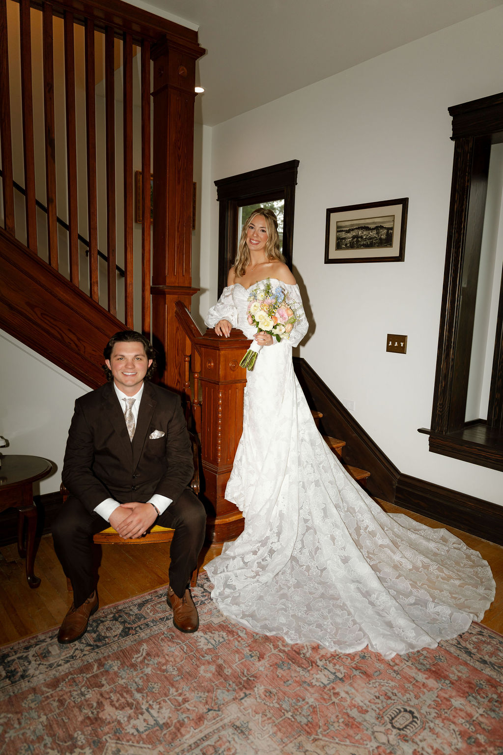 Bride and groom posing for a wedding portrait beside a wooden staircase.