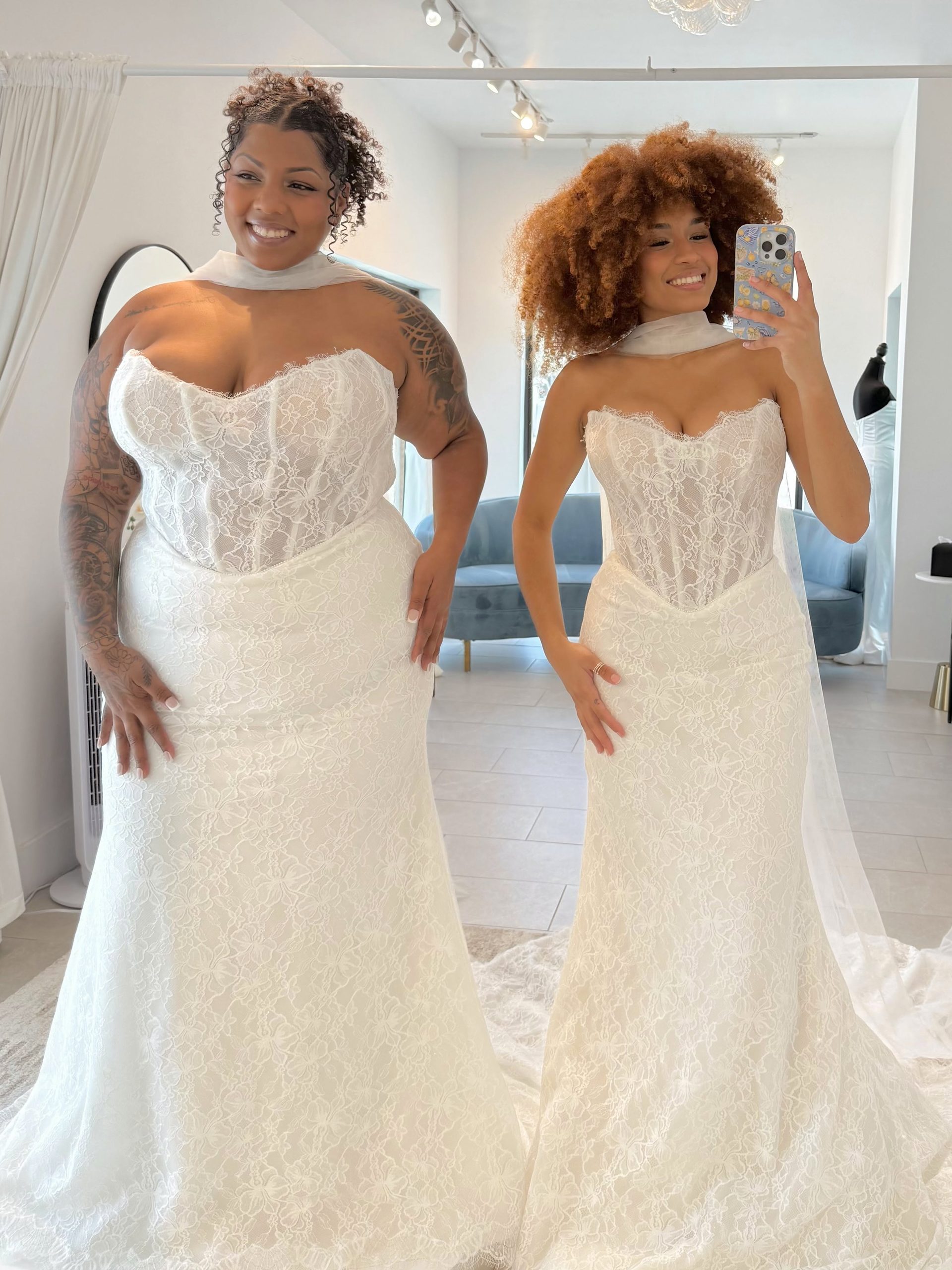 Two brides showcasing fitted lace wedding dresses with structured corset bodices at Savvy Bridal.