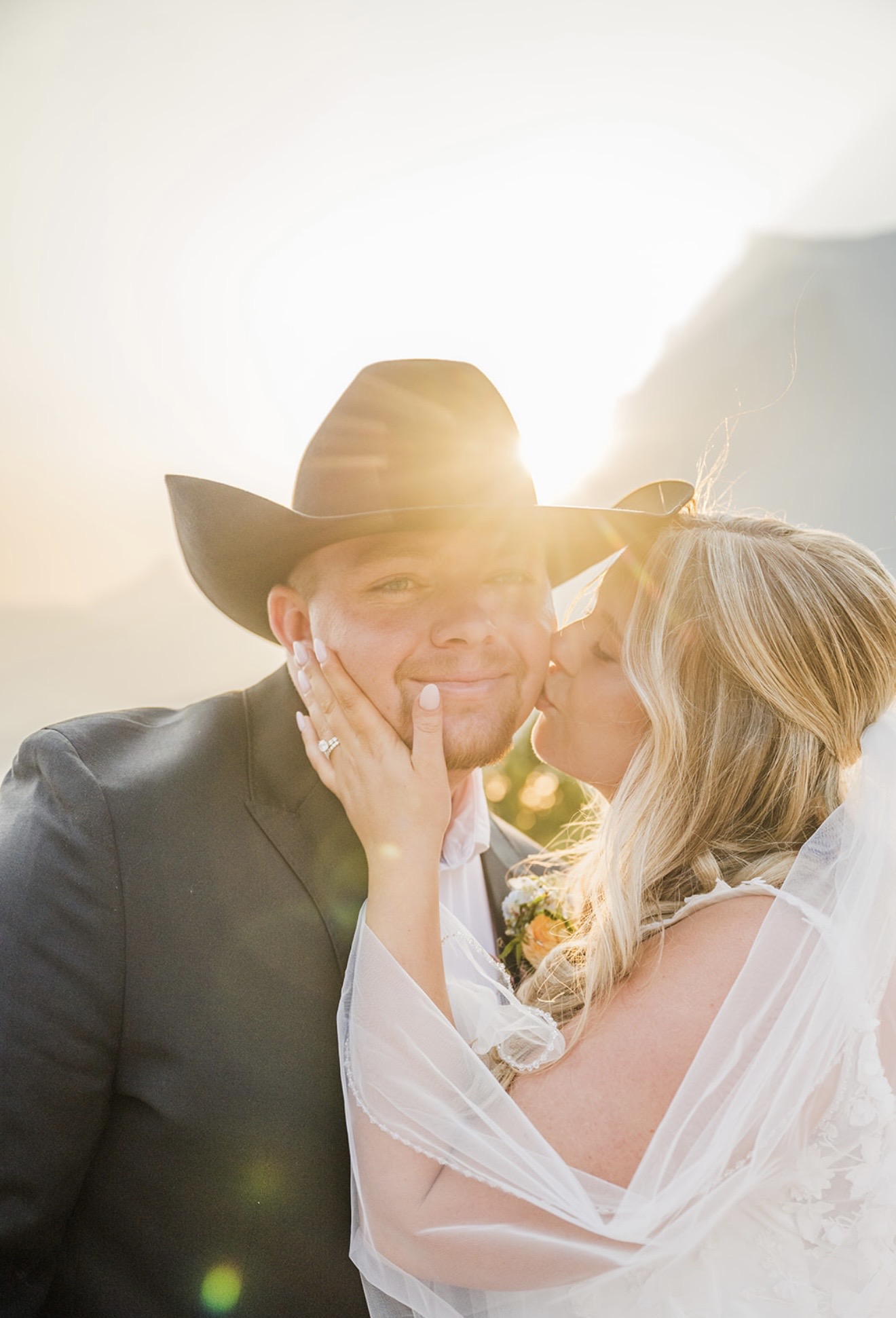 Annabelle kiss Zack on check with beautiful sunset and breathtaking mountain background
