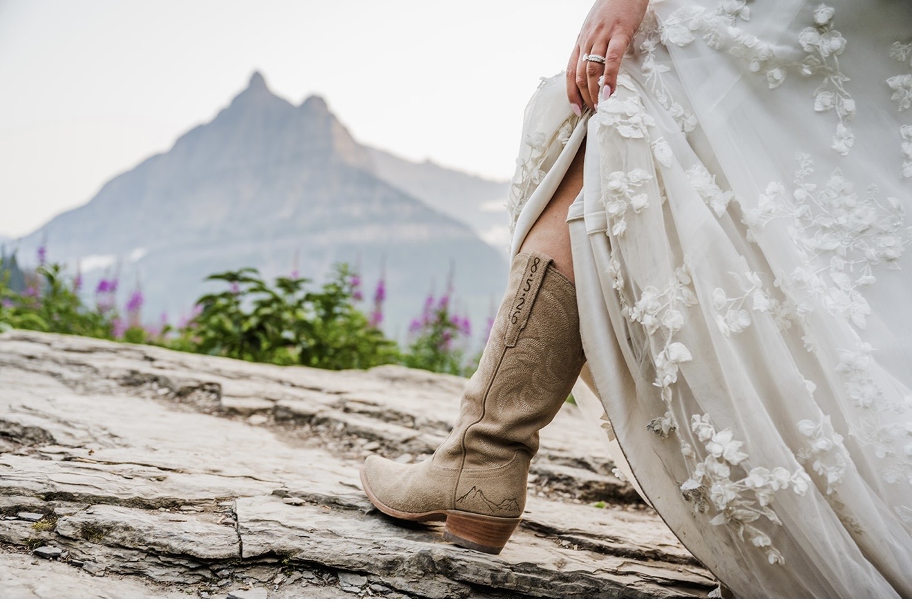 Annabelle pairs her romantic floral wedding gown with Tecovas cowboy boots for her Glacier National Park wedding.