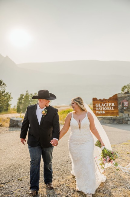 Annabelle and Zack walking hand in hand at Glacier National Park wedding.