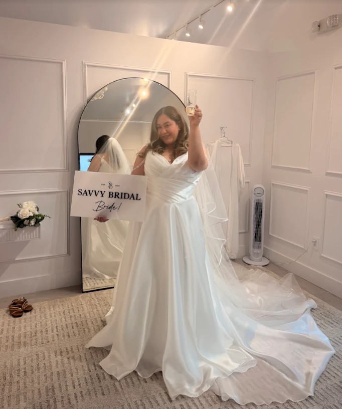 Bride celebrates saying yes to the dress at Savvy Bridal while holding an “I Said Yes” sign.